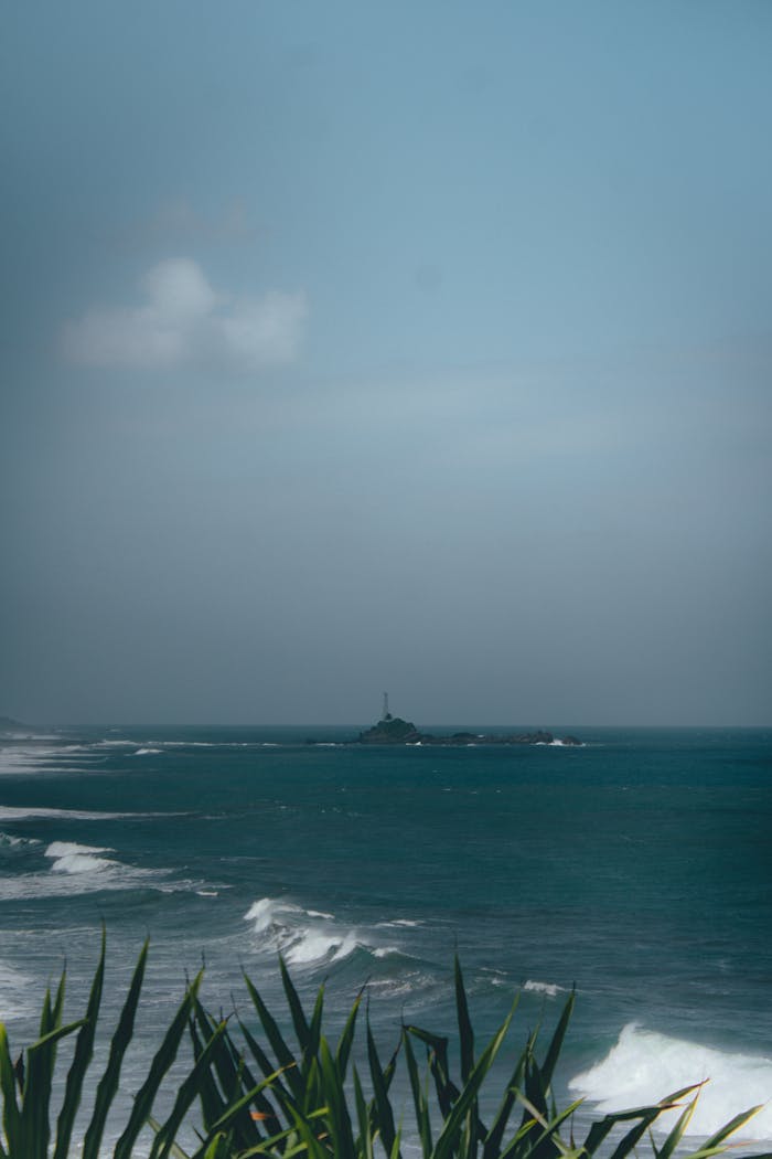 Peaceful ocean view featuring a distant lighthouse in Tasikmalaya, West Java, Indonesia.